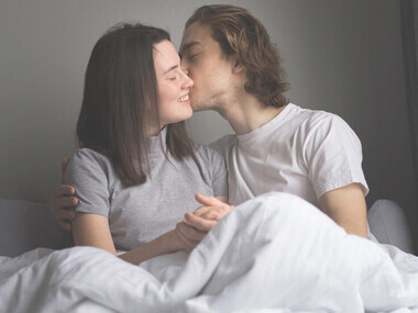 Romantic couple in bed sharing a close embrace, symbolizing intimacy and relationship connection