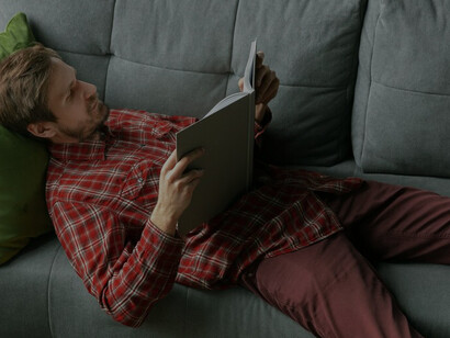 A young man lounging on the sofa at home epitomizes the laziness fostered by today's convenience culture