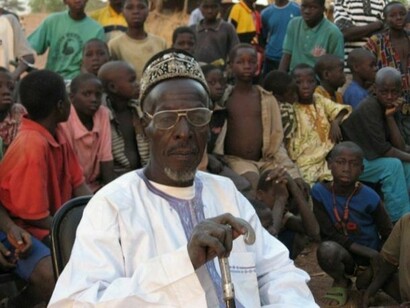 An old Sakouli man, surrounded by children