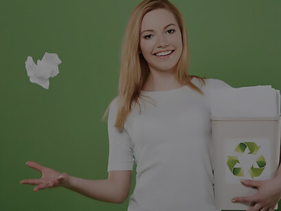 A woman holds a box full of papers for recycling