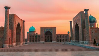 Registan Square in Samarkand, Uzbekistan, glowing at sunset as its blue-tiled madrasas shimmer like a doorway into another age
