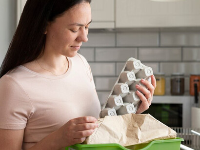 A woman holds an eco-friendly egg carton, emphasizing her dedication to sustainable packaging and responsible consumption