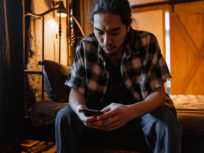 Lost in the glow of his phone, the weight of online expectations and the quiet room mirror his growing sense of isolation