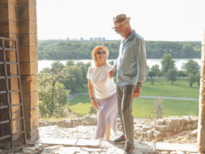 Elderly couple embracing the scenic beauty of Tuscany, Italy, showcasing the charm of Italian countryside vacations
