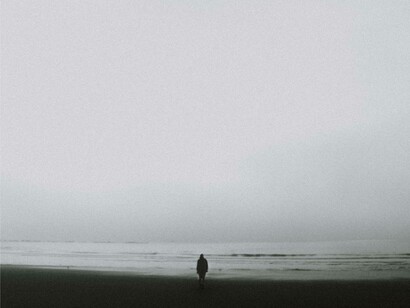 A person alone walking on a once populated beach after the effect of population decline