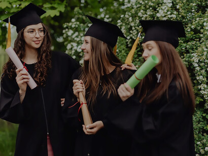 Clad in their graduation robes and caps, three students strike a pose, radiating accomplishment and celebrating the culmination of their university experience