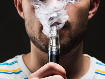 The face of a young man vaping