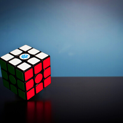 Hands holding a Rubik's cube; by stripping a problem down to its core elements, we free ourselves from the constraints of conventional thinking and open the door to novel solutions