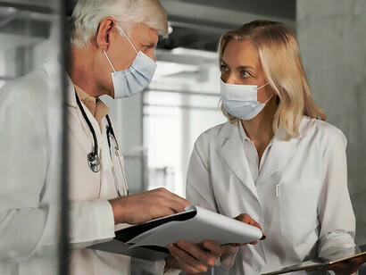 Dois médicos conversando. O objetivo é aproveitar a série de workshops públicos que ocorreram no atual programa de desenvolvimento de medicamentos com foco no paciente