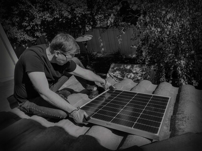 The solar panel installer sets the panel evenly on the roof tiles