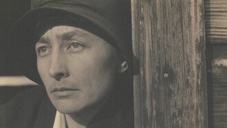 Georgia O'Keeffe con cappello nero, contro lo stipite di una porta di legno - fotografia di Alfred Stieglitz, Metropolitan Museum of Art, New York, Usa