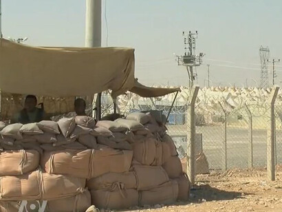 A Syrian refugee center on the Turkish border, with tents amidst the devastation of the Syrian war, highlighting the ongoing humanitarian crisis, Turkey