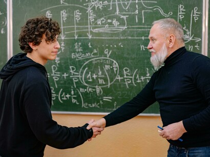 Docente y alumno estrechando las manos. La universidad tiene el potencial de transformar la humanidad si adopta nuevas metodologías que fomenten la creatividad, la sabiduría y el desarrollo ético