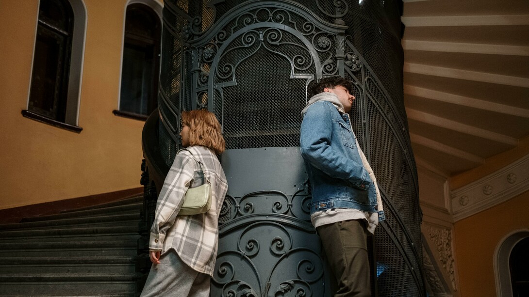 Two people facing away from each other on the stairs