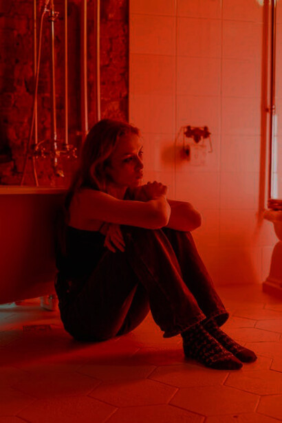 A woman sitting on the bathroom floor