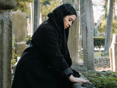 Woman touching the grave of a loved one