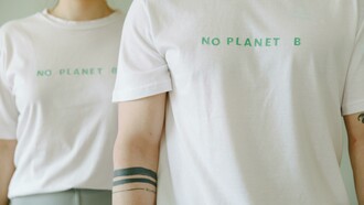 People wearing white-themed shirts with slogans such as ‘No Planet B,’ representing sustainable fashion and eco-friendly clothing for the future
