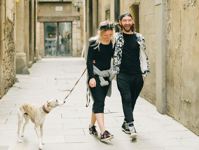 A couple taking the dog for a walking in Barcelona's old neighbourhood