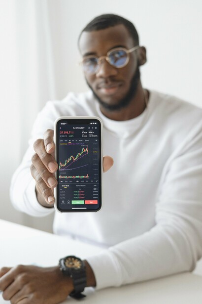 A person holding up a phone with a graph on it