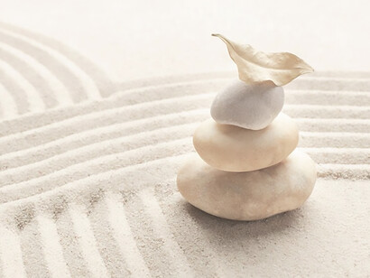 Stacked zen marble stones against a sandy background, evoking mindfulness and tranquility in this conceptual image