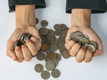 A successful businesswoman managing finances and coins on her desk, highlighting the drive for profit in capitalism
