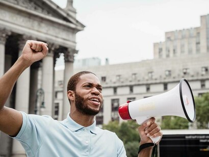 A protestor with a megaphone urging the masses to unite for the cause