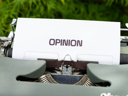 A typewriter typing the words, "opinion"