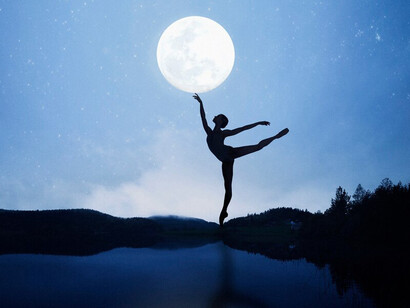 A person's silhouette reaching for the Aquarian New Moon, surrounded by cosmic energy