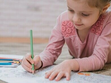 Una bambina che scrive contenta