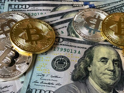 The bitcoin and the US dollar note, representing the new and traditional types of money
