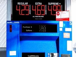 A sign for a gas station with a clock on it