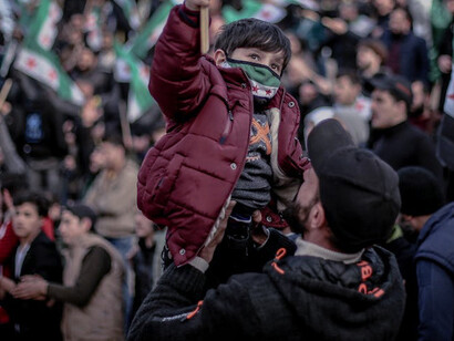 With unwavering resolve, a boy joins protesters as they stand together, reminding the world that the pursuit of peace is a shared responsibility, essential for all humanity