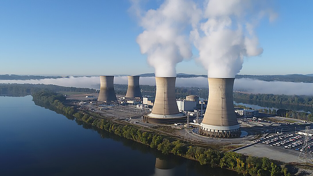 The working cooling towers of Exelon Generation Unit 1 in the foreground are emitting water vapor. The dormant cooling towers are from Unit 2, which was permanently damaged in the 1979 accident, Pennsylvania, USA