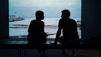 A couple reconnecting in front of the ocean