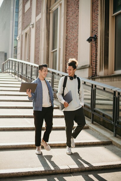 Two people walking together at a university. Universities are for teaching, research and extension