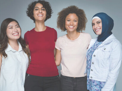 A multicultural group of women standing together, posing to celebrate diversity