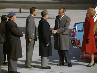 President Nixon shaking hands with Chou EnLai standing at the foot of the Air Force One stair ramp