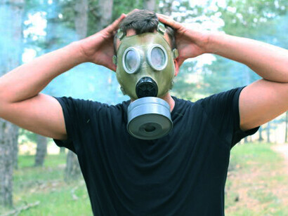A man in a protective rubber mask surrounded by hazardous conditions, representing the looming nuclear threat and climate change impact
