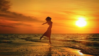 Em silhueta contra o céu dourado, uma mulher salta diante do mar ao pôr do sol. A imagem traduz a sensação de liberdade e de abertura para novas possibilidades que atravessa o texto