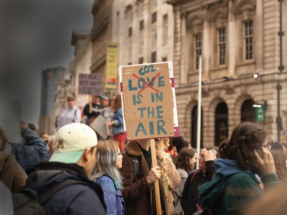 Protestors in England carrying signs that have the word 'love' marked out and that reads "Co2 is in the air" as their way of expressing their awareness of the climate crisis