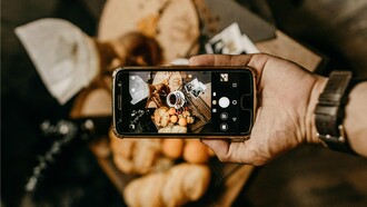 Homem tira foto para post a respeito de comida de restaurante. Um trabalho que até pouco tempo atrás era feito somente por críticos gastronômicos, especialistas que trabalham para veículos de comunicação e que faziam questão de visitar os restaurantes anonimamente, com grande compromisso com a imparcialidade, hoje já parece não ter mais tanta relevância