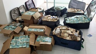 Malas e caixas com parte dos R$ 51 milhões em dinheiro vivo apreendidos pela Polícia Federal em um apartamento atribuído ao ex-ministro Geddel Vieira Lima (do partido MDB), em Salvador (BA), em 2017. O imóvel ficou conhecido como "bunker do Geddel" e se tornou um dos maiores símbolos da corrupção e do desvio de recursos públicos na história recente do Brasil, embora tenham surgido novos casos como fraudes contra aposentados e pensionistas do INSS e os desdobramentos do caso Banco Master, que recolocaram corrupção, fiscalização e responsabilização no centro da agenda nacional