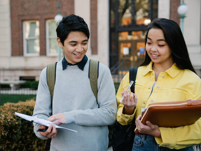 Two students comparing notes after class