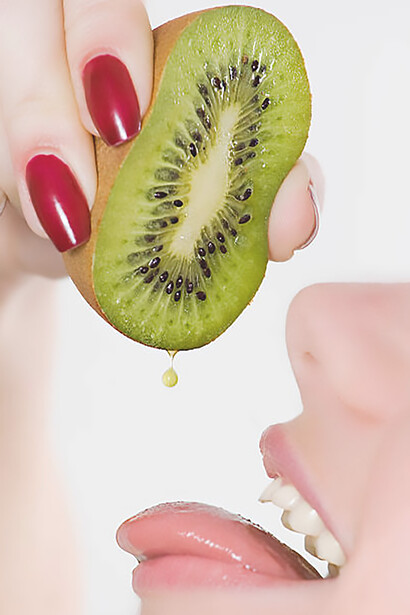 Savor the moment with a captivating image of a woman tasting kiwi, showcasing taste buds, receptors, and sweet treats