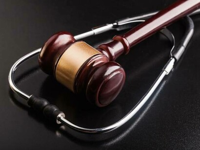 A gavel and stethoscope on a wooden table symbolize the fight for social justice and the legal complexities surrounding healthcare disparities