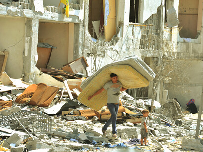 In the aftermath of devastation, a man and child stand together, embodying the fragile hope for peace amid the chaos of destruction