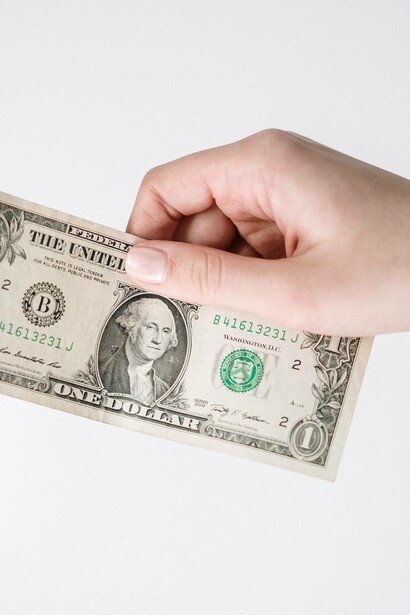 A dollar bill being handed over