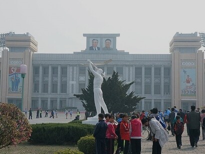 Atleti della Maratona di Pyongyang del 2014 davanti all'ingresso del Kim Il-sung Stadium, Pyongyang, Corea del Nord