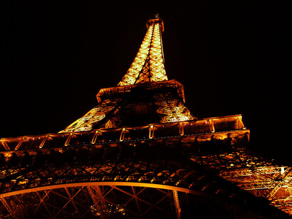 A low shot of a fully lit Eiffel Tower against the night sky