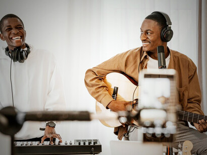 Amapiano music with a captivating front view image of male musicians at home, playing guitar and piano, embodying the soulful essence of amapiano melodies